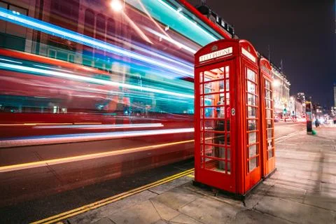 Light trails of a double decker bus next to the iconic telephone booth in London Stock Photos