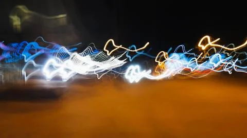 Light trails weaving dynamic patterns, illuminating dark space with vivid color Stock Photos