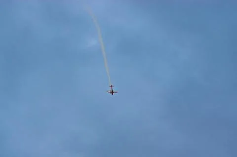 Light training plane doing loop in dark skies Foto stock