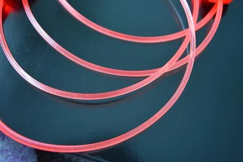 Light transparent wire, cable, polyethylene tubes of red, orange, yellow, pink. Stock Photos