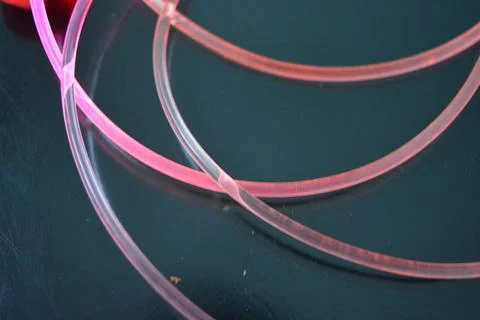 Light transparent wire, cable, polyethylene tubes of red, orange, yellow, pink. Stock Photos