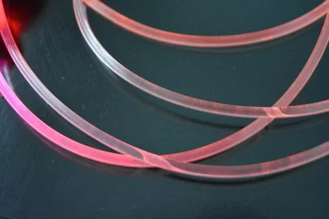Light transparent wire, cable, polyethylene tubes of red, orange, yellow, pink. Stock Photos
