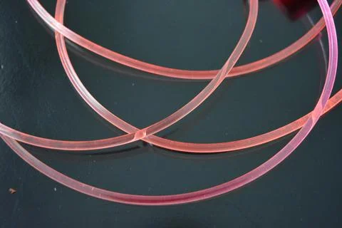 Light transparent wire, cable, polyethylene tubes of red, orange, yellow, pink. Stock Photos
