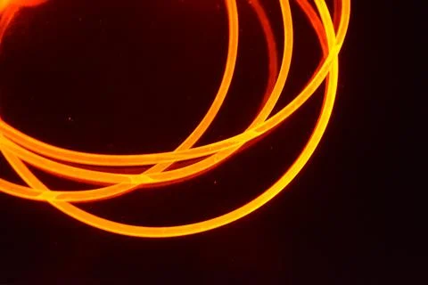 Light transparent wire, cable, polyethylene tubes, rods of red, orange. Stock Photos