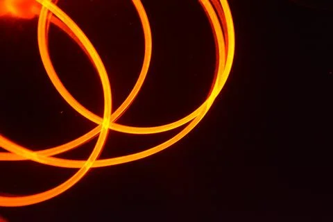 Light transparent wire, cable, polyethylene tubes, rods of red, orange. Stock Photos