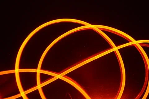 Light transparent wire, cable, polyethylene tubes, rods of red, orange. Stock Photos