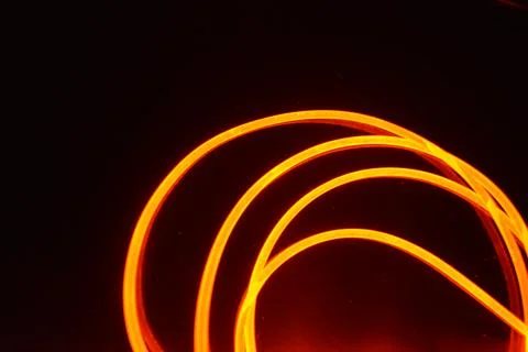 Light transparent wire, cable, polyethylene tubes, rods of red, orange. Stock Photos