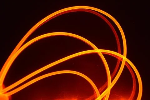 Light transparent wire, cable, polyethylene tubes, rods of red, orange. Stock Photos