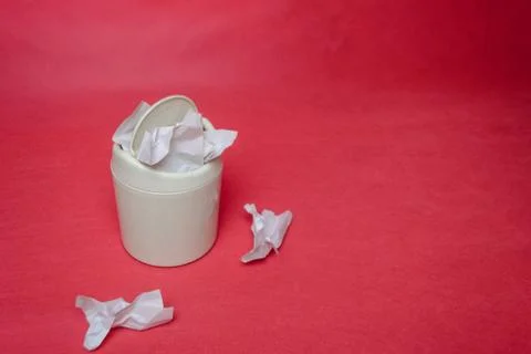 Light trash bin on red background. Closeup of crumpled sheets of paper. Conce Stock Photos