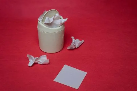 Light trash bin on red background. Closeup of crumpled sheets of paper. Conce Stock Photos