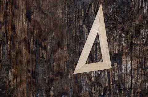 A light triangular ruler on a dark wooden background. A special geometric too 写真素材
