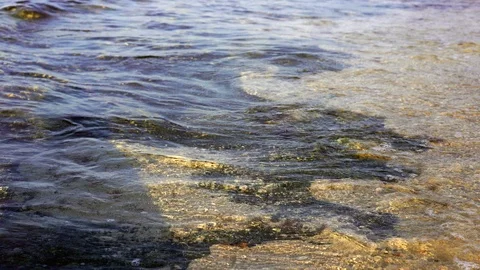 Light tropic sea waves on the beach. Rocky bottom and clear water. High Exposure Stock Footage 94810865
