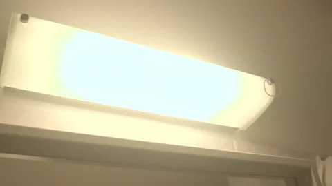 Light turns on with soft hum and warm brightness in bathroom Stock-Footage 333890923