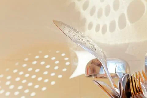 Light on the wall from the kitchen skimmer, or frying spoon. Stock-Fotos