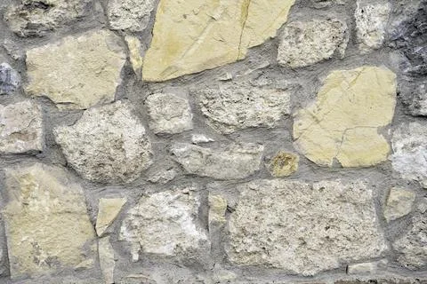 Light wall of large rough limestone stones Stock Photos