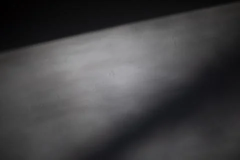 Light on the wall. Shadow on the wall. White surface in low light. Stock Photos