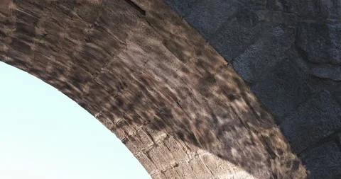 Light from water ripples in river, reflected on underside of old stone bridge Video stock 134500852