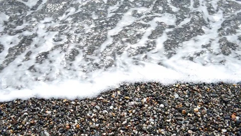 Light wave moves small stones on the shoreline Stock Footage 88631949