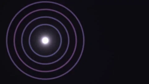 Light waves expand in concentric circles on a dark Stock Footage 338276619