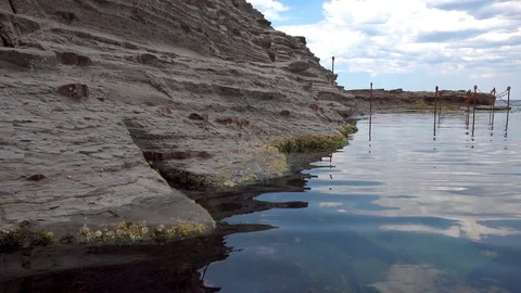 Light waves go through the water near the rocks Stock Footage 121651721