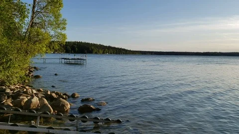 Light waves rolling across a lake next to dock Stock Footage 122146142