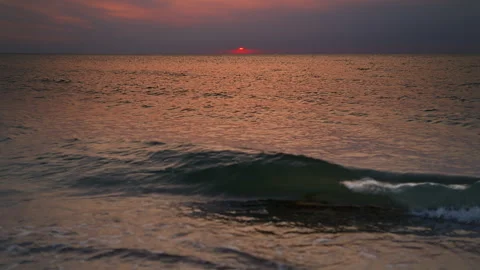Light waves on the sea on a warm evening with the setting sun barely visible. Video stock 283580844