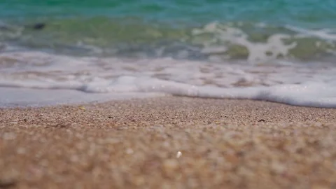 Light waves wash the sandy beach closeup Stock Footage 126786585