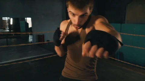 Light weight boxer punch the camera on the ring in vintage gym Stock Footage 87831613