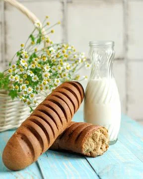 Light wheat loaf bread and glass jar of milk. Freshly baked food. Light rustic Stock Photos