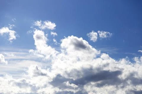 Light white fluffy clouds float across the blue sky. Texture of clouds and sk Stock Photos