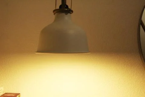A light white lamp in the twilight. Lighting problems in a room, apartment, h Stock Photos
