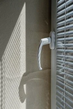 The light from the window falls on the wall, the shadow lines from the blinds Foto stock