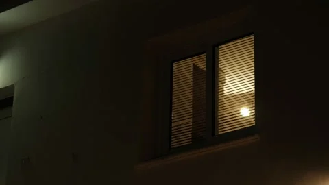 Light from the window of the house in the dark evening time. room lights up then Stock Footage 159152865
