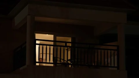 Light from the window of the house in the dark evening time. room lights up then Stock Footage 159192676