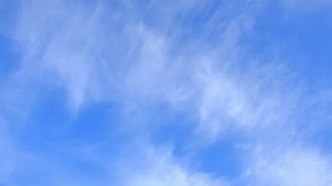 Light wispy cirrus clouds floating in a bright blue sky. Cirrus clouds. Summer Stock Footage 343781707