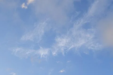 Light wispy cloud formations scattered over vibrant blue sky for clean sky Stock Photos