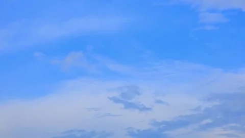 Light wispy clouds floating in a bright blue sky. Natural background, weather Stock Footage 343781450