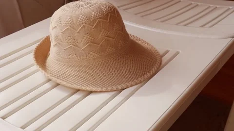 Light women's hat falls on white plastic sun lounger, FullHD Stock Footage 144731147