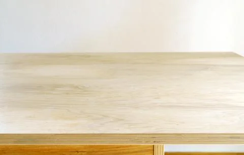 Light wooden table surface against a white wall for product display Stock Photos