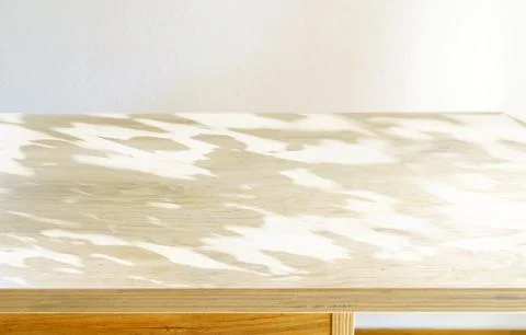 Light wooden table surface against a white wall for product display Stock Photos