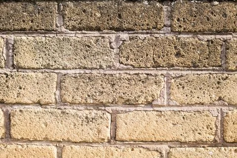 Light yellow brick wall background. Horizontal photo of beige rock fence Stock Photos