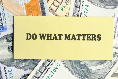 A light yellow card with the text Do What Matters sits on a surface covered with Stock Photos