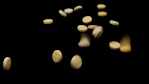 Light yellow tablets falling on a completely black surface Video stock 147550105