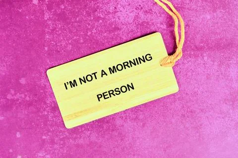 A light yellow tag rests on a textured, bright pink surface. The tag declar.. Foto stock