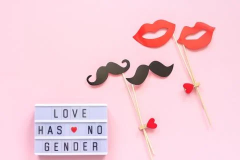 Lightbox text Love has no gender, couple paper mustache lips props on pink ba Stock Photos