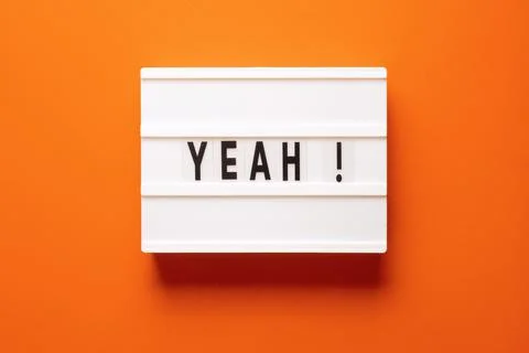 Lightbox with word yeah on orange background, top view. Space for text Stock Photos