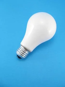 Lightbulb on blue background Stock Photos