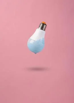 Lightbulb with blue liquid floating in pink background Stock Photos