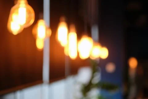 Lightbulb in cafe blurred background. Stock Photos