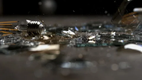 A Lightbulb Falls onto a Table and Shatters Into Pieces Stock Footage 270408832